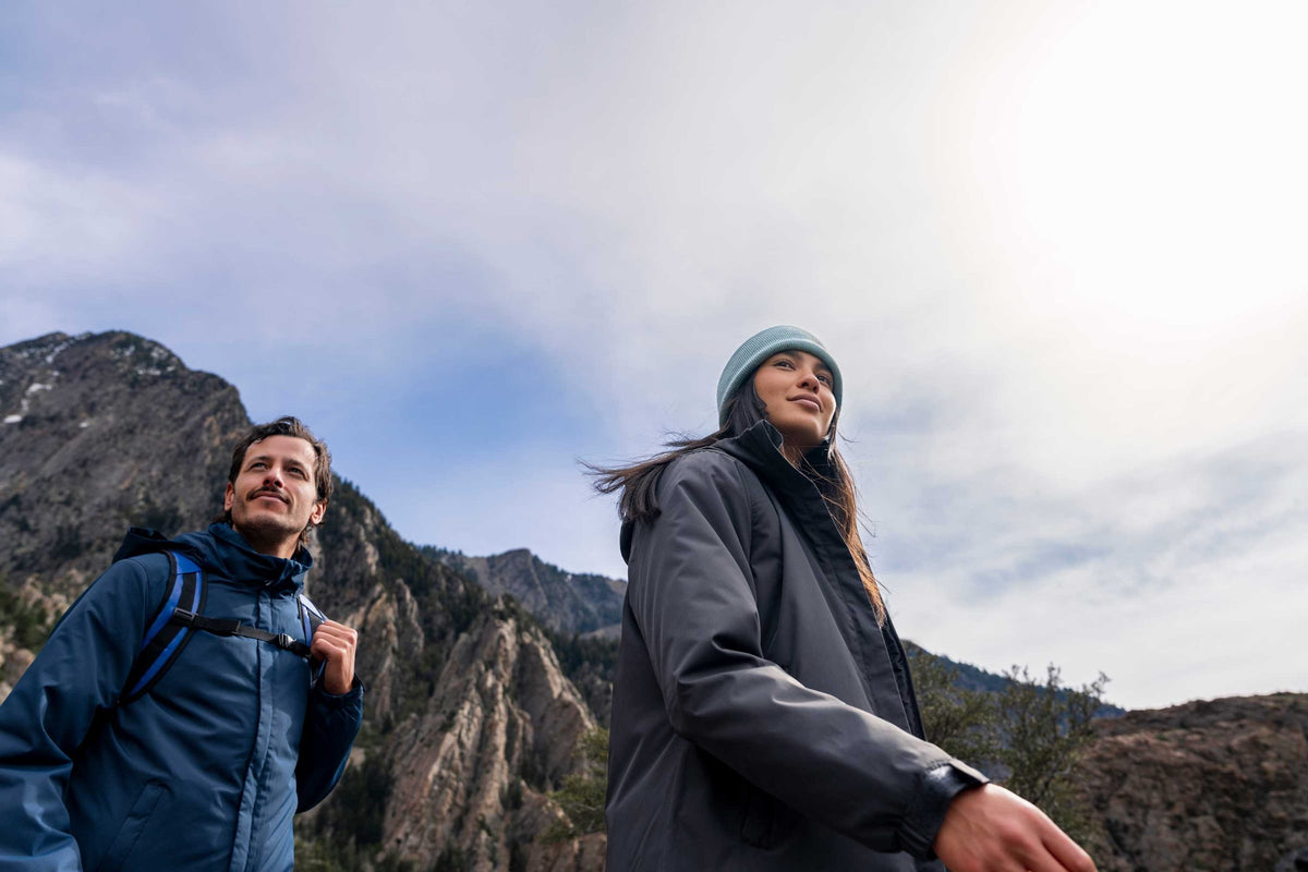 Two hikers in Stormtech insulated jackets on a mountain trail