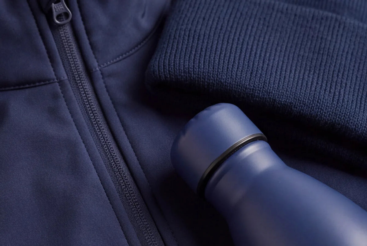 Navy softshell jacket, beanie and water bottle ready for your team's logo from the B2B Shop